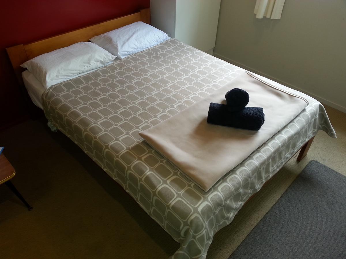 Riverstone Lodge Turangi Exterior foto A bed with a duvet